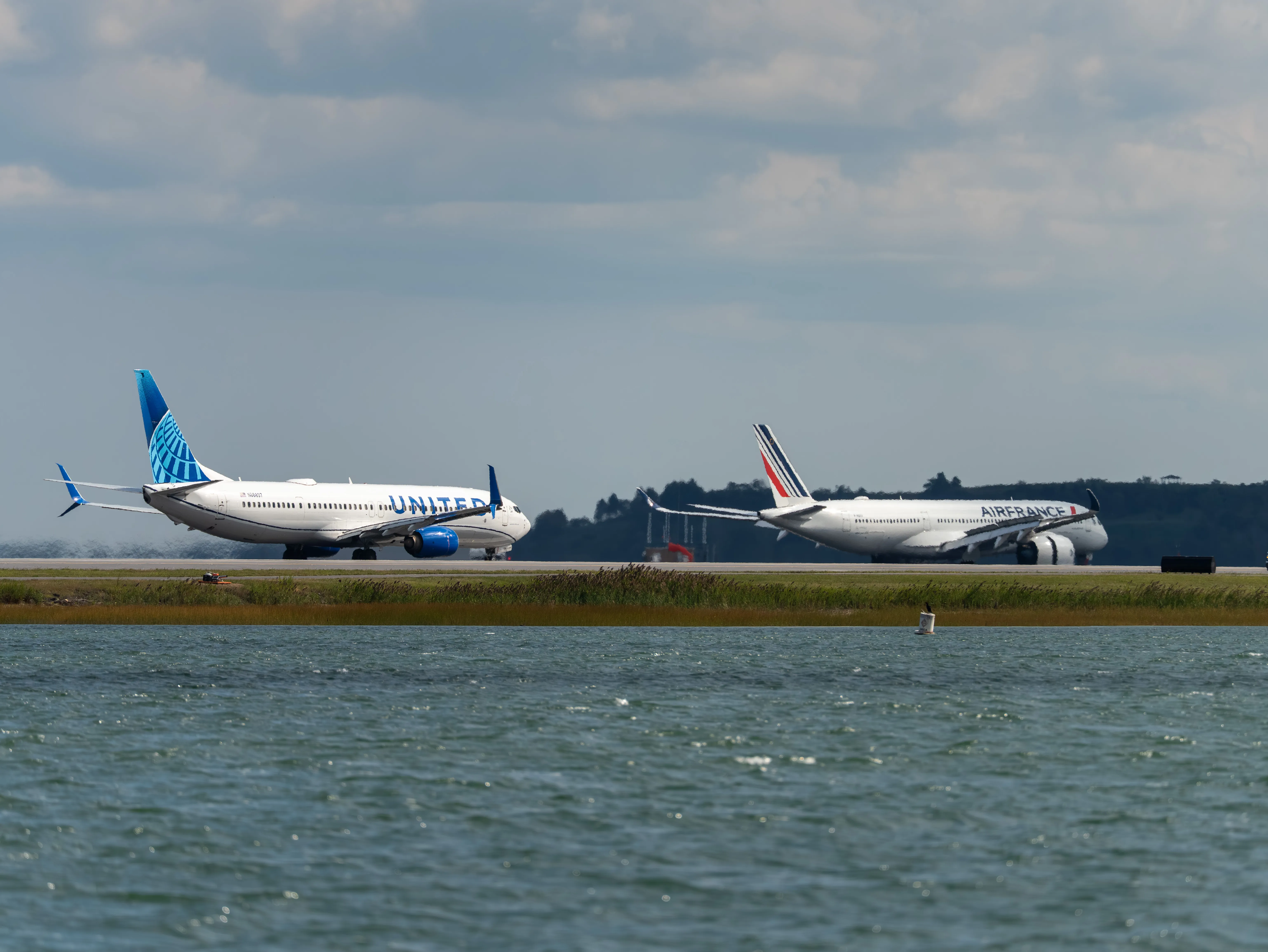 United Airlines Boeing B737-924ER (registration number N66897) was taking off and Air France Airbus A350-941 (registration number F-HUVA) was braking with thrust reversal deployed in the same photo