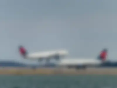 Two Delta Aeroplanes: Delta Air Lines Airbus A330-323 (N801NW) Making Final Approach and Delta Air Lines Embraer E175LR (N219YX) Taxiing