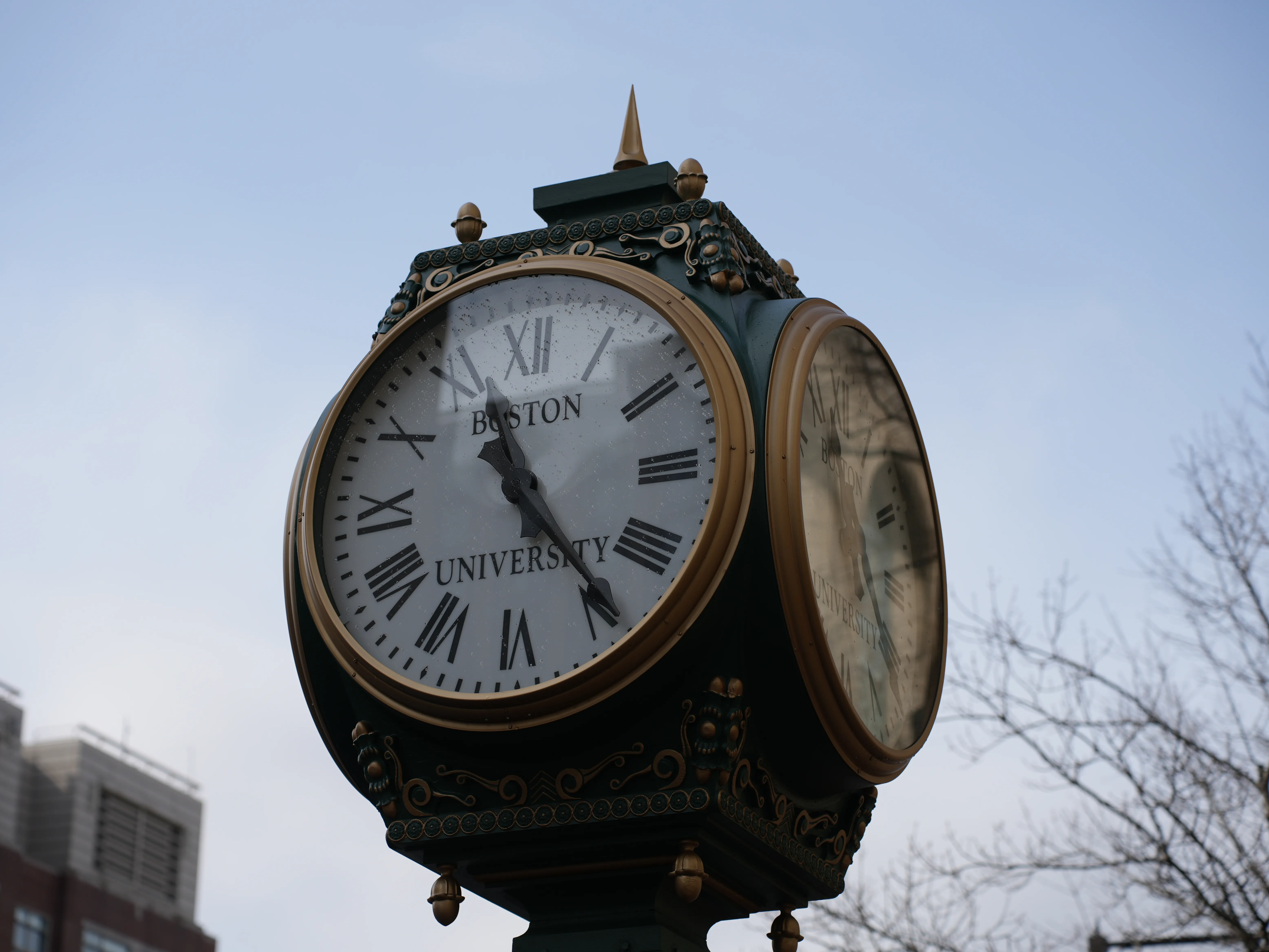 A four-faced roadside clock bearing the Boston University mark