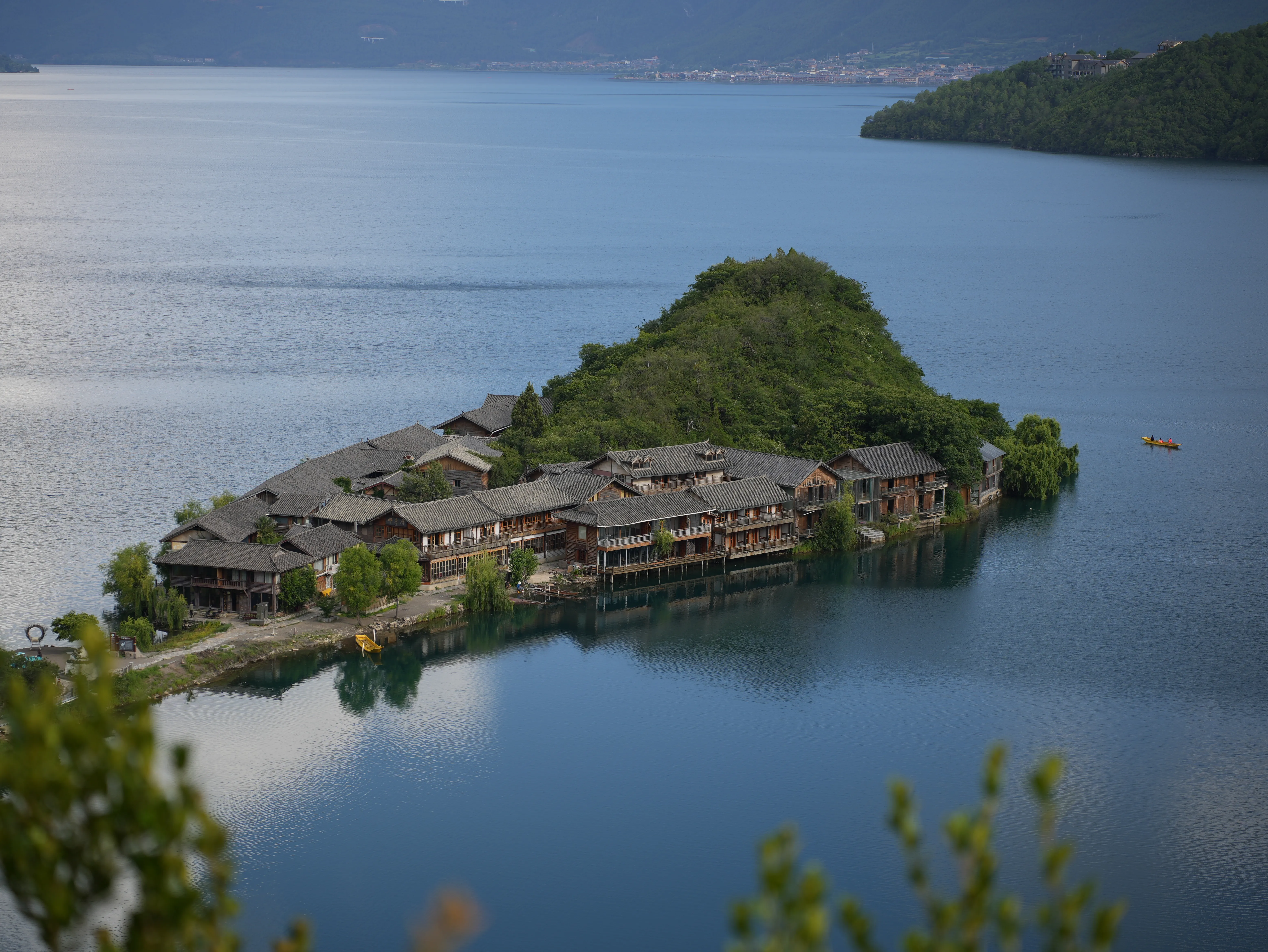 An Island on Lugu Lake with traditional Chinese architecture on it, forming a illusion of a lilliputian village