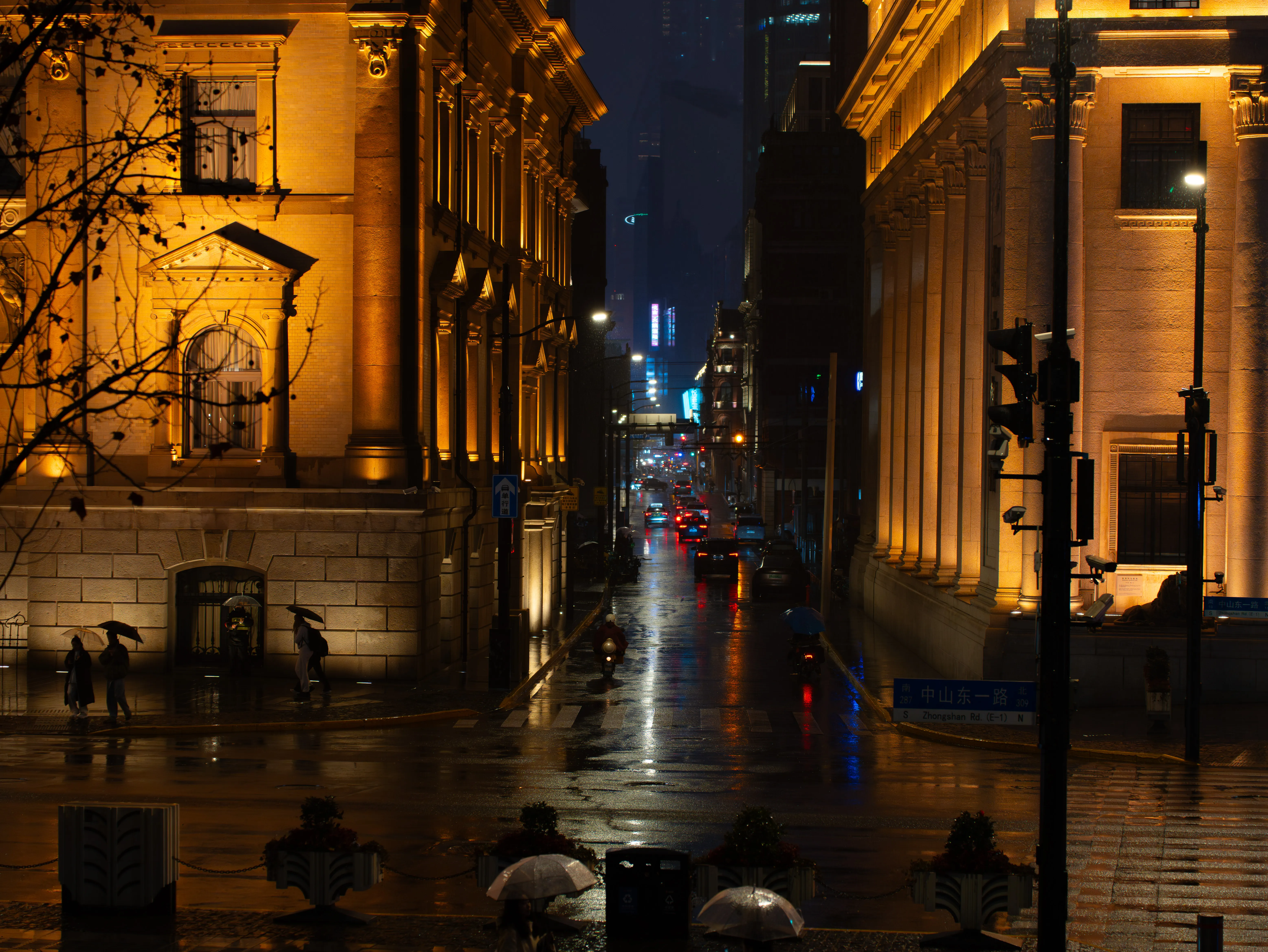 Cars on the Jiujiang Road with old amber buildings and high blue buildings in the background (night sight)